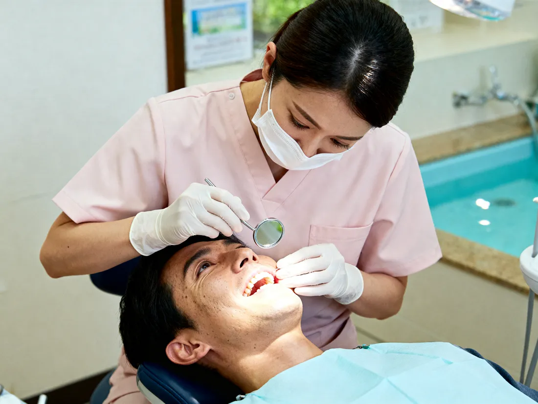 A hygienist cleaning a patient's teeth